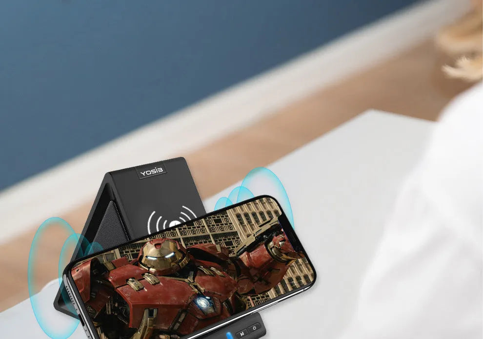 Black multifunctional Bluetooth speaker unit with integrated wireless charging pad and phone stand.