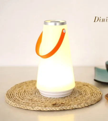 White rechargeable LED bedside night light with adjustable warm glow on wooden table