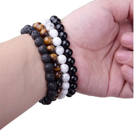 A geometric black onyx bracelet for women with 8mm beads on an elastic cord.