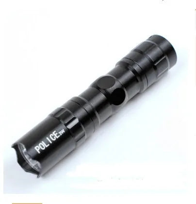 Black aluminium alloy mini LED flashlight showing compact size next to a AA battery for scale.