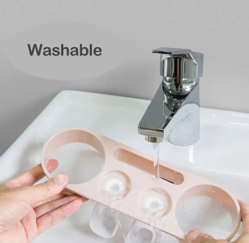 Plastic wall-mounted toothbrush holder with four magnetic cups in pink, blue, and green for family bathroom