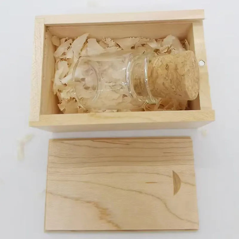 Wooden-capped transparent glass bottle USB flash drive on a wooden surface.