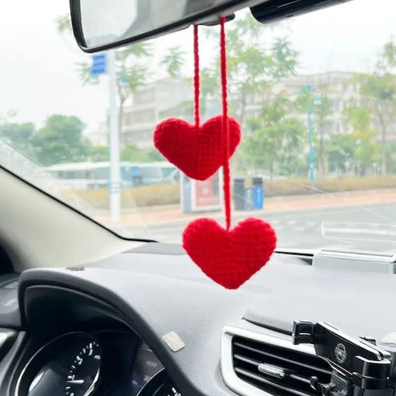 Green and white knitted wool car plant decoration with hanging rope on car dashboard
