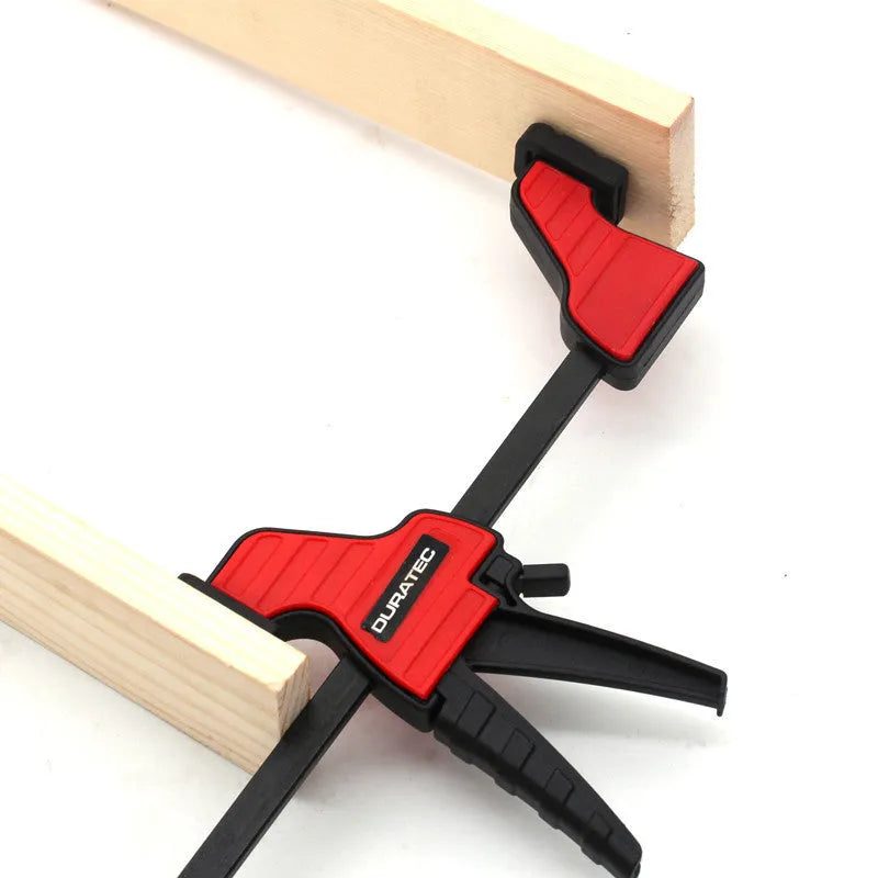 Black plastic woodworking clamp with quick release mechanism and rubber grip jaws