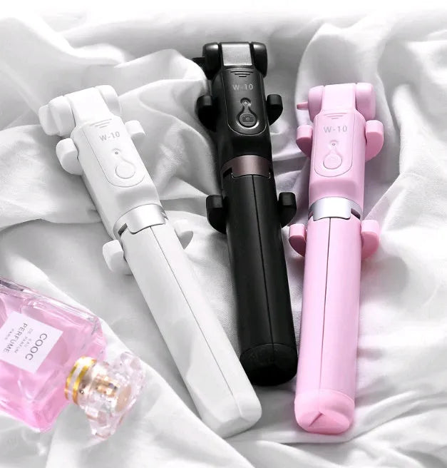 Aluminium Bluetooth selfie stick with tripod base and remote control next to a mobile phone.