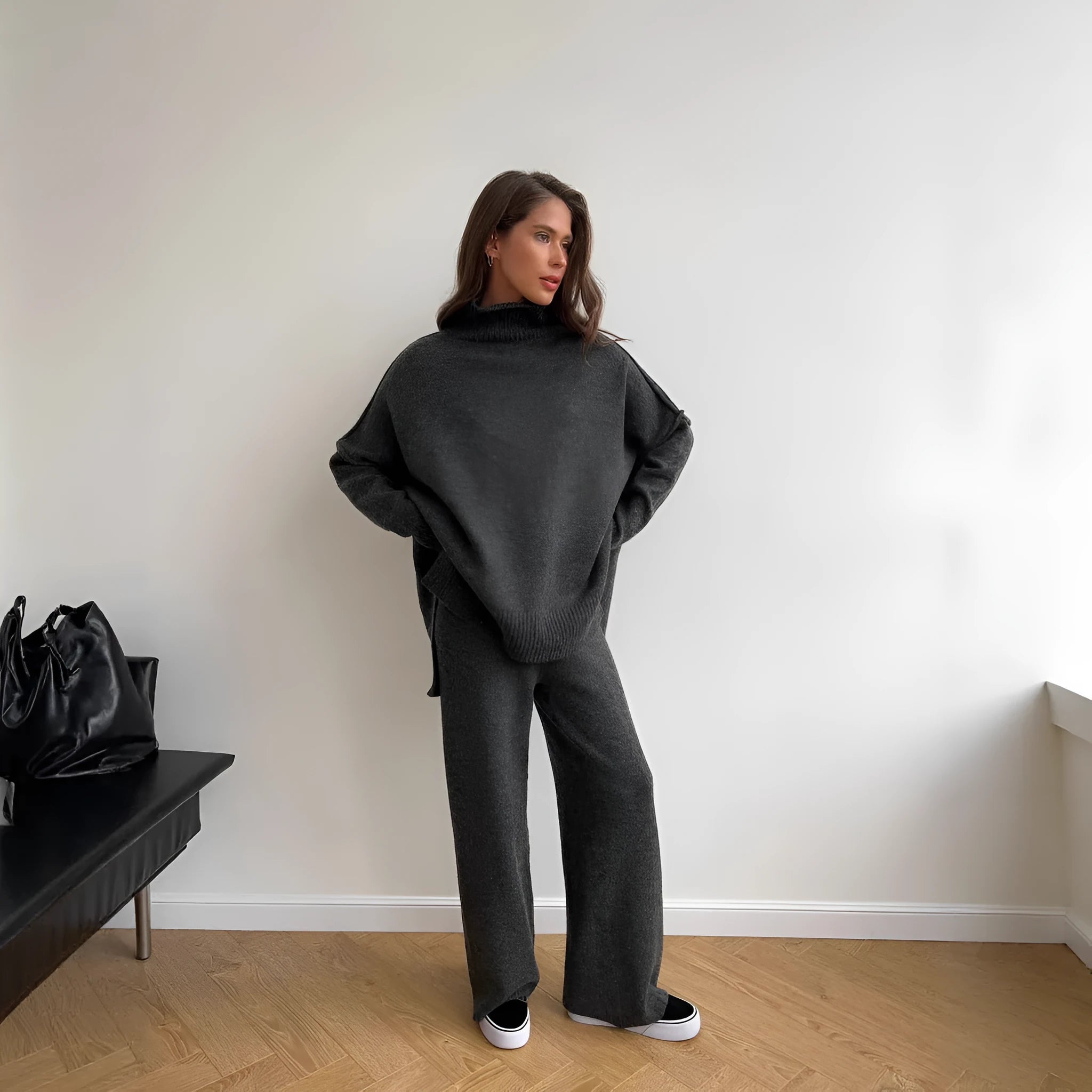Women's dark grey knit co-ord suit with side-slit sweater and matching trousers laid flat.