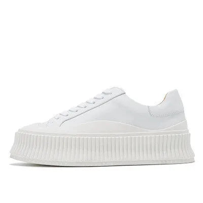 Women's black suede platform sneakers with back lacing, cross binding detail, and a thick sole on a white background.