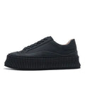 Women's black suede platform sneakers with back lacing, cross binding detail, and a thick sole on a white background.