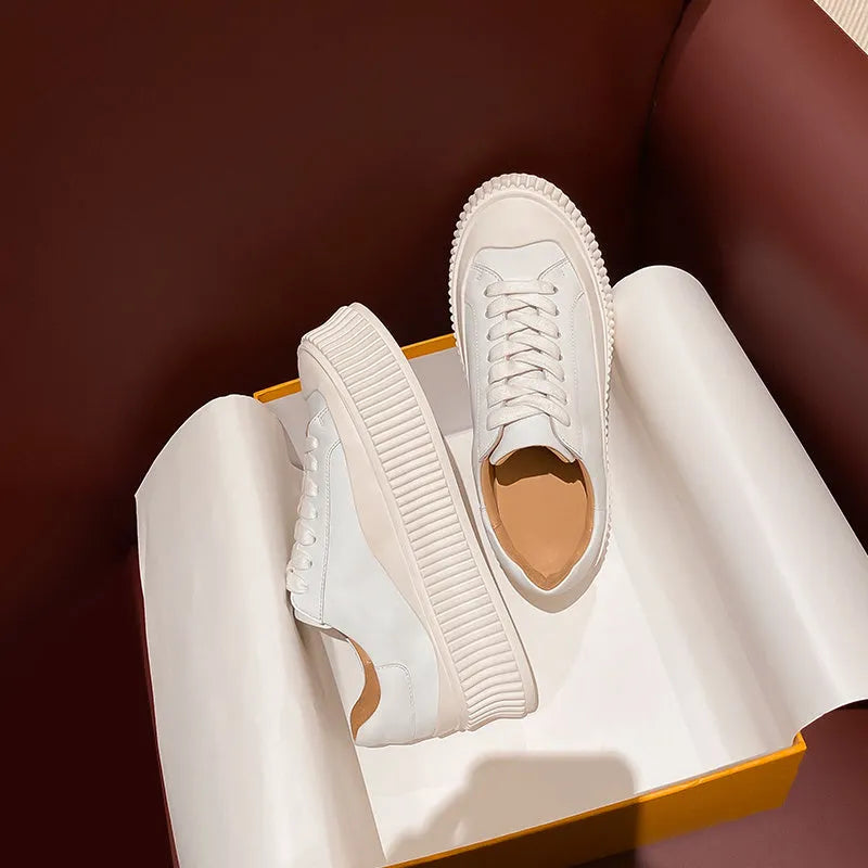 Women's black suede platform sneakers with back lacing, cross binding detail, and a thick sole on a white background.