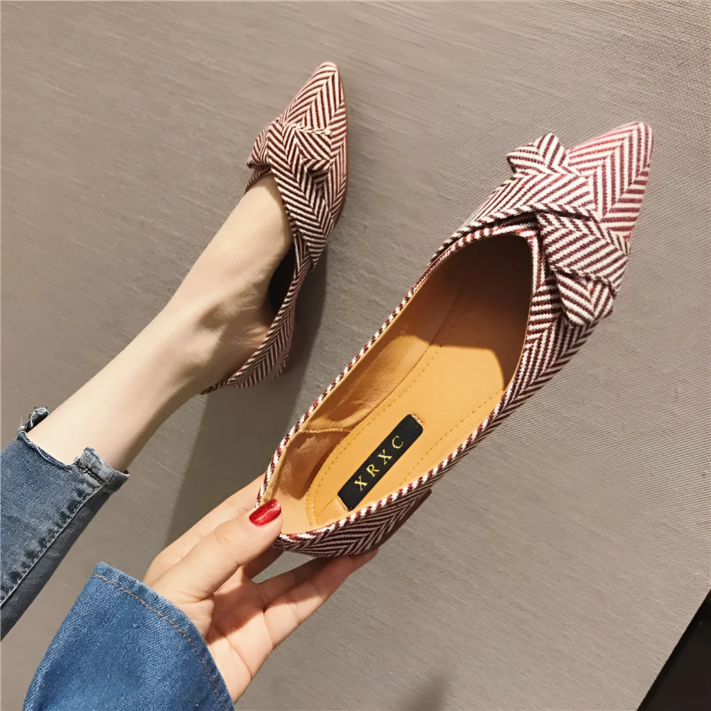 Women's red and black pointed-toe low-heel flats with a shallow mouth opening, shown from the side.