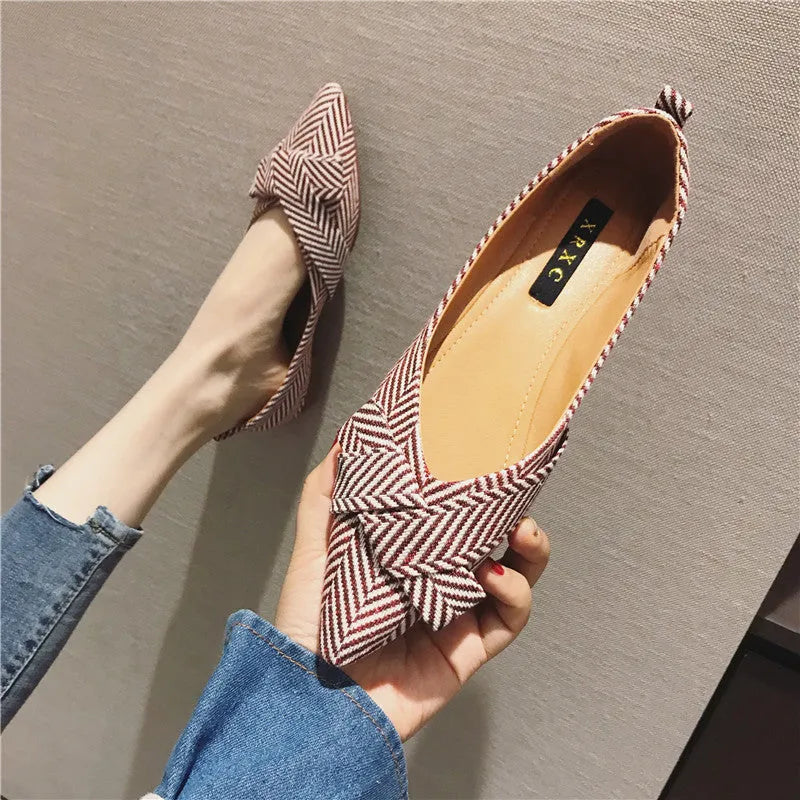 Women's red and black pointed-toe low-heel flats with a shallow mouth opening, shown from the side.