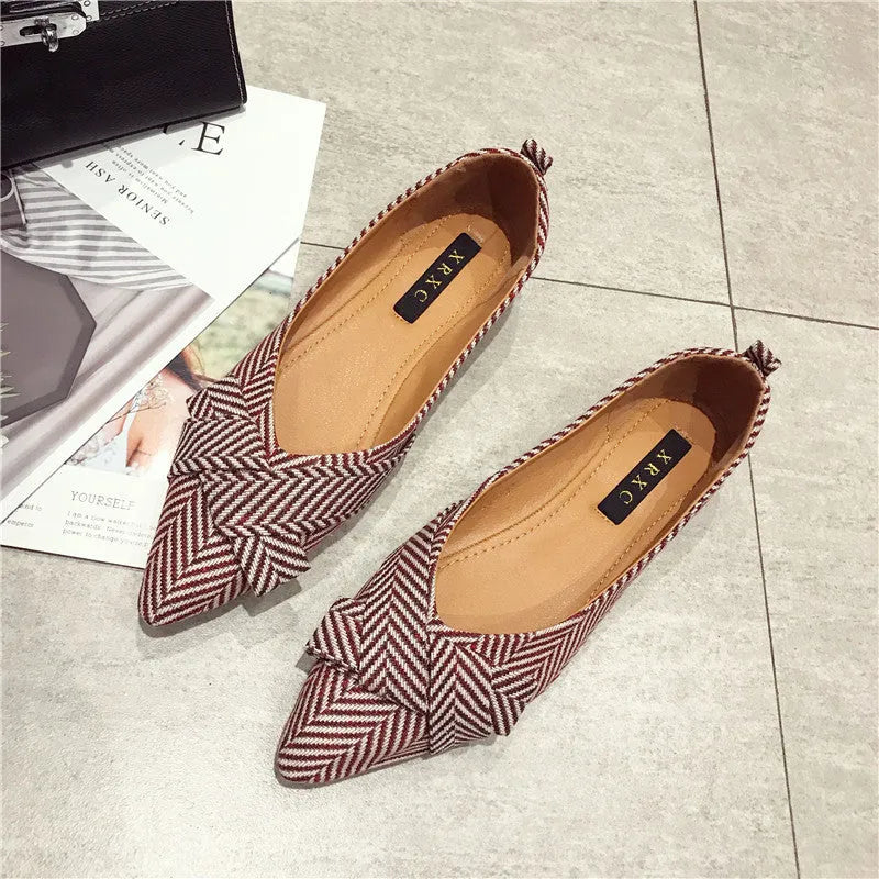 Women's red and black pointed-toe low-heel flats with a shallow mouth opening, shown from the side.