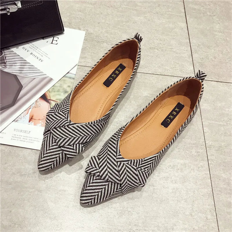 Women's red and black pointed-toe low-heel flats with a shallow mouth opening, shown from the side.