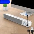 Small black and white desktop wired computer speakers on a desk.