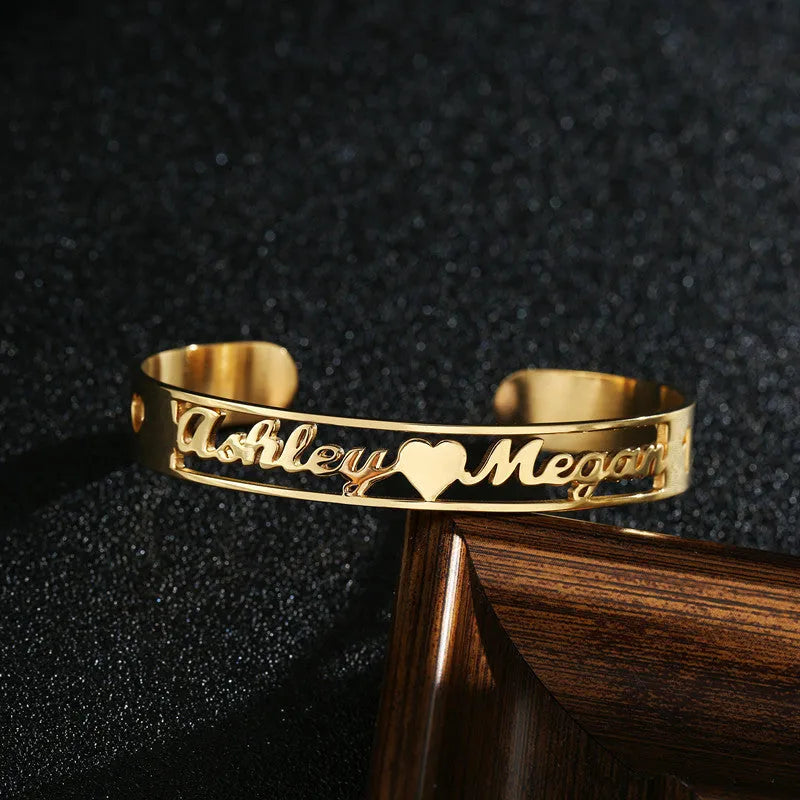 Custom engraved name bangle in stainless steel, silver colour finish, shown on a flat surface