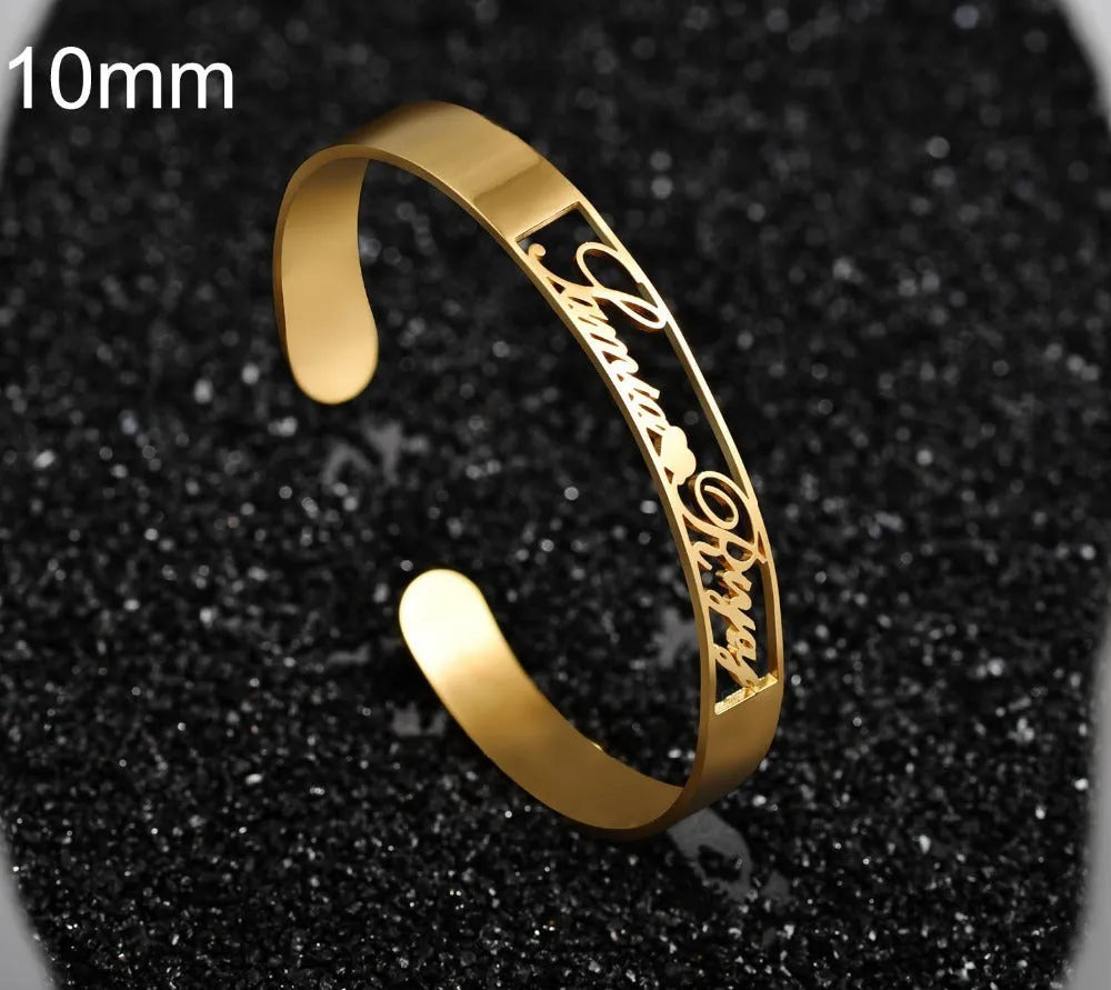 Custom engraved name bangle in stainless steel, silver colour finish, shown on a flat surface