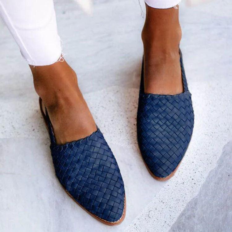 A pair of flat buckle sandals with a pointed toe, shown in one of the available colours.