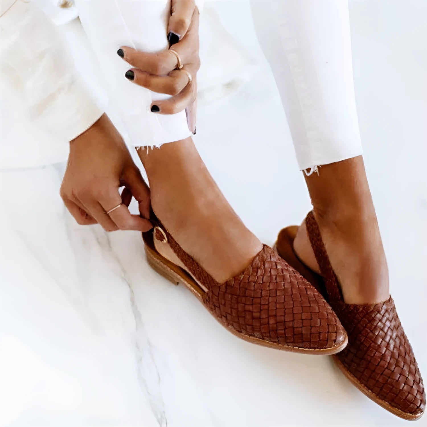 A pair of flat buckle sandals with a pointed toe, shown in one of the available colours.