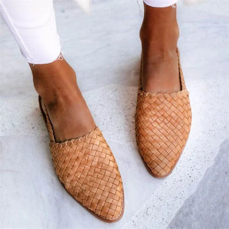 A pair of flat buckle sandals with a pointed toe, shown in one of the available colours.