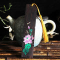 Painted lotus bookmark set in sandalwood with two designs showing landscape and flower patterns