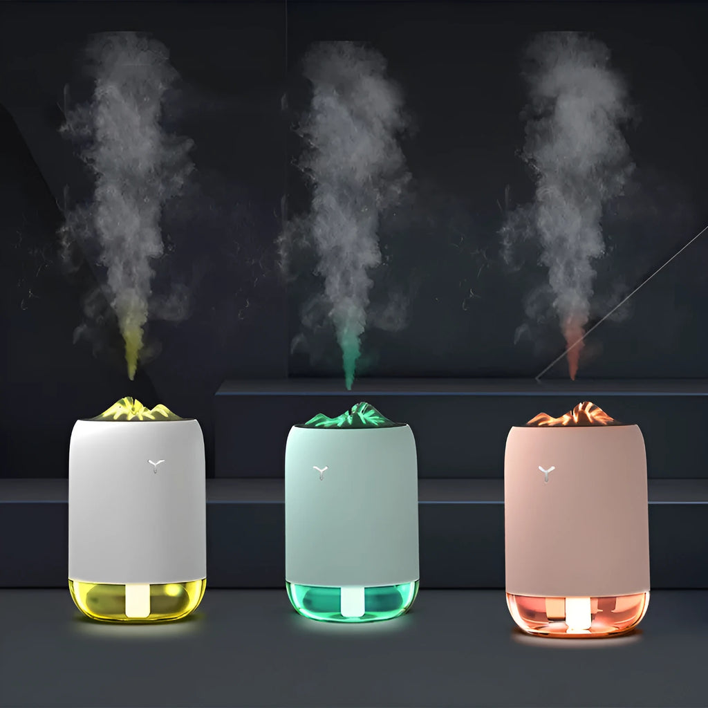 Magic Flame columnar humidifier in light blue on a wooden desk, showing USB cable and single mist outlet.