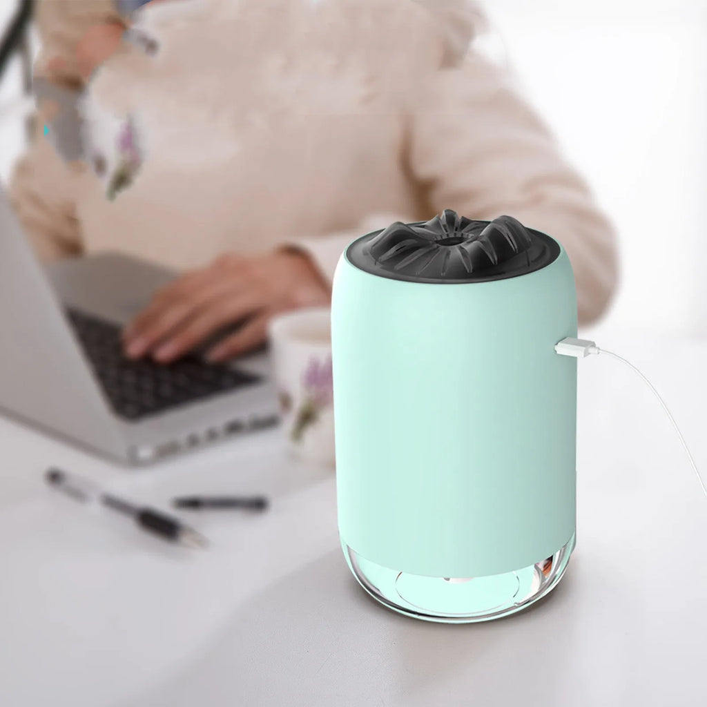 Magic Flame columnar humidifier in light blue on a wooden desk, showing USB cable and single mist outlet.