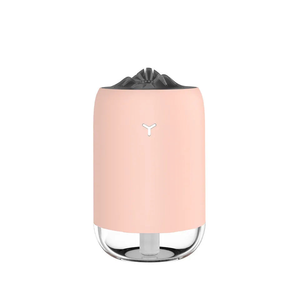 Magic Flame columnar humidifier in light blue on a wooden desk, showing USB cable and single mist outlet.