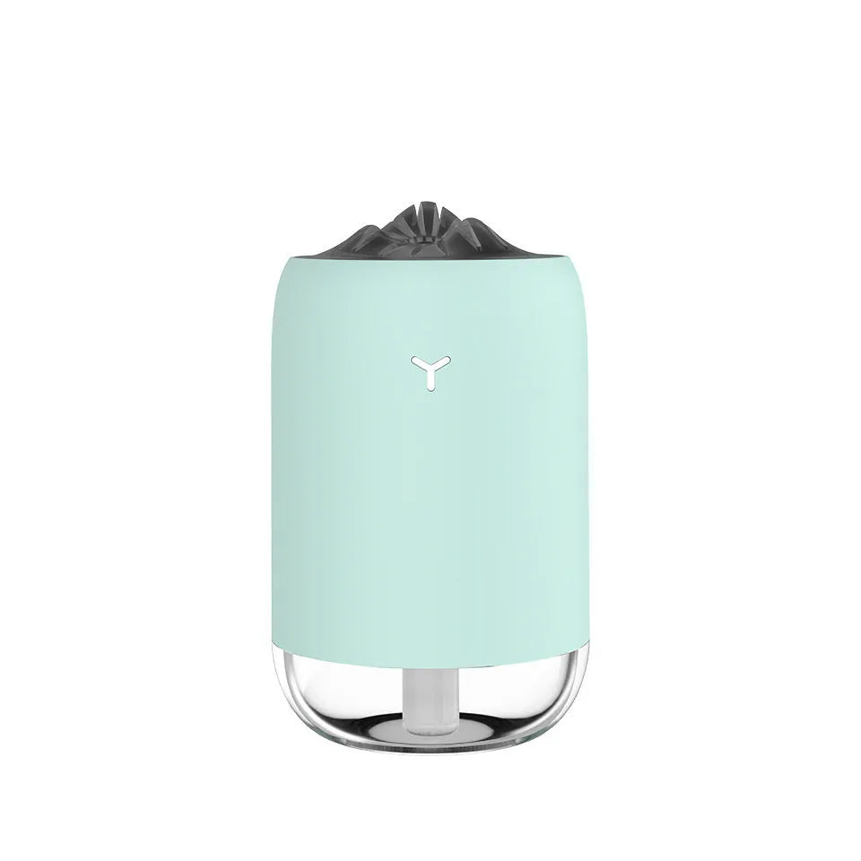 Magic Flame columnar humidifier in light blue on a wooden desk, showing USB cable and single mist outlet.