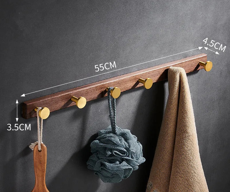 Black walnut bathroom clothes hook row with brass-finished aluminium hooks in perforated mounting design