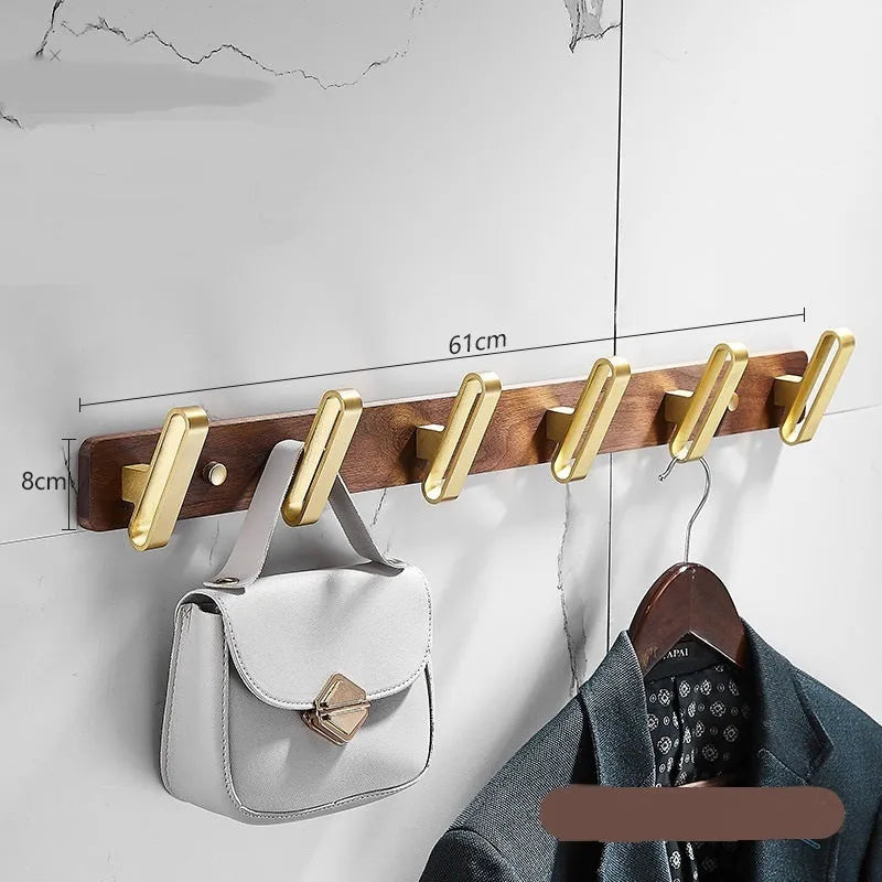 Black walnut bathroom clothes hook row with brass-finished aluminium hooks in perforated mounting design