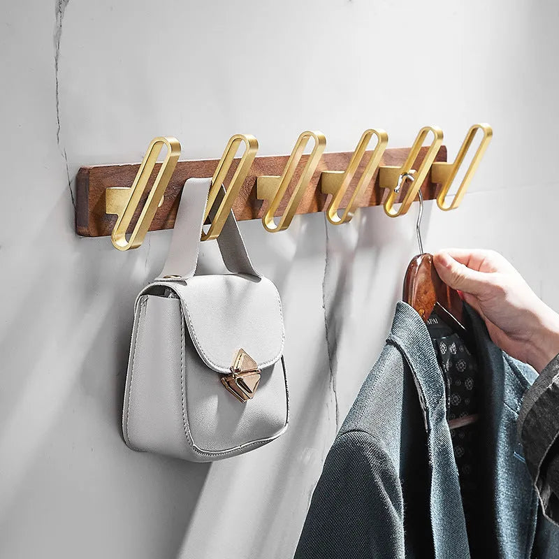 Black walnut bathroom clothes hook row with brass-finished aluminium hooks in perforated mounting design