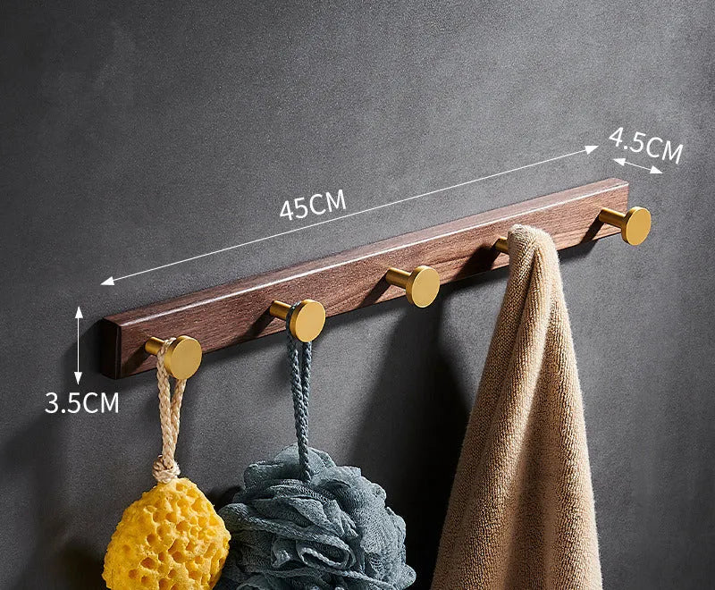 Black walnut bathroom clothes hook row with brass-finished aluminium hooks in perforated mounting design