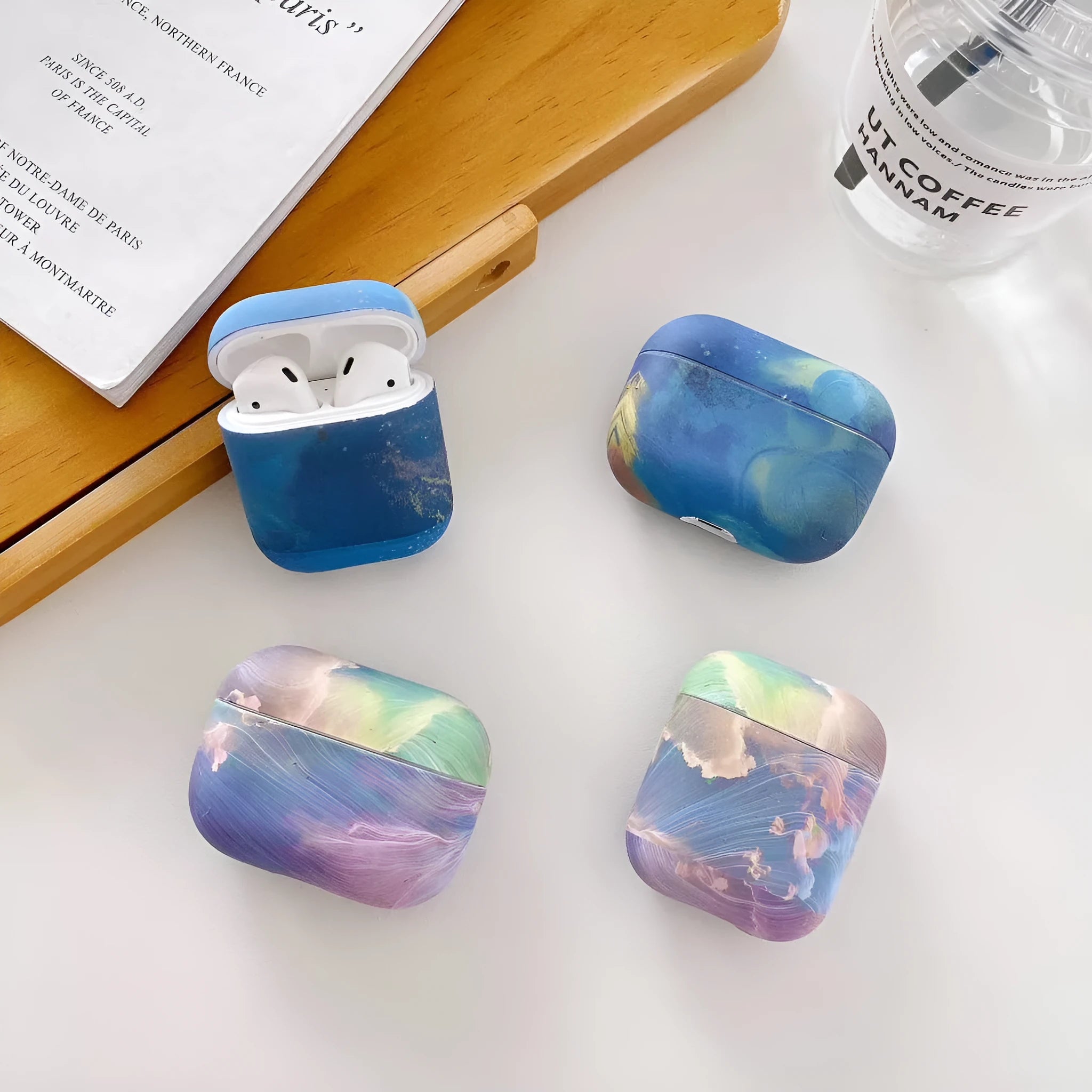 Hard plastic protective case for AirPods with pink and blue watercolour design.
