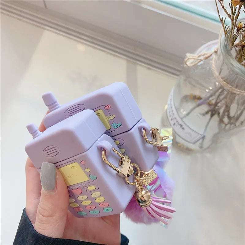 Purple silicone AirPods case with clamshell design and fur ball pendant