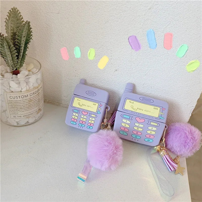 Purple silicone AirPods case with clamshell design and fur ball pendant