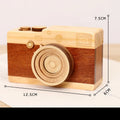 Small wooden music box with rotating camera decoration on pine wood base.