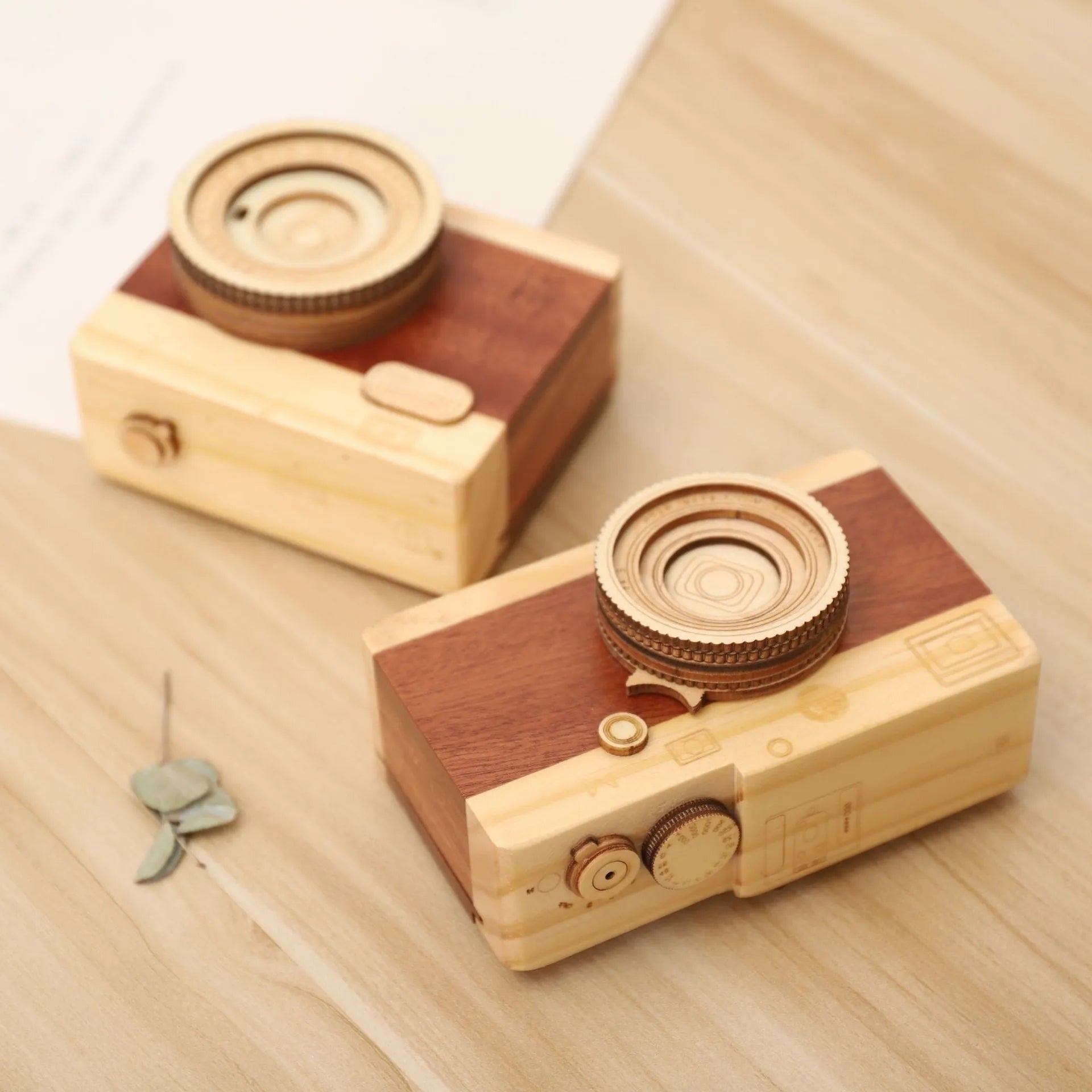 Small wooden music box with rotating camera decoration on pine wood base.