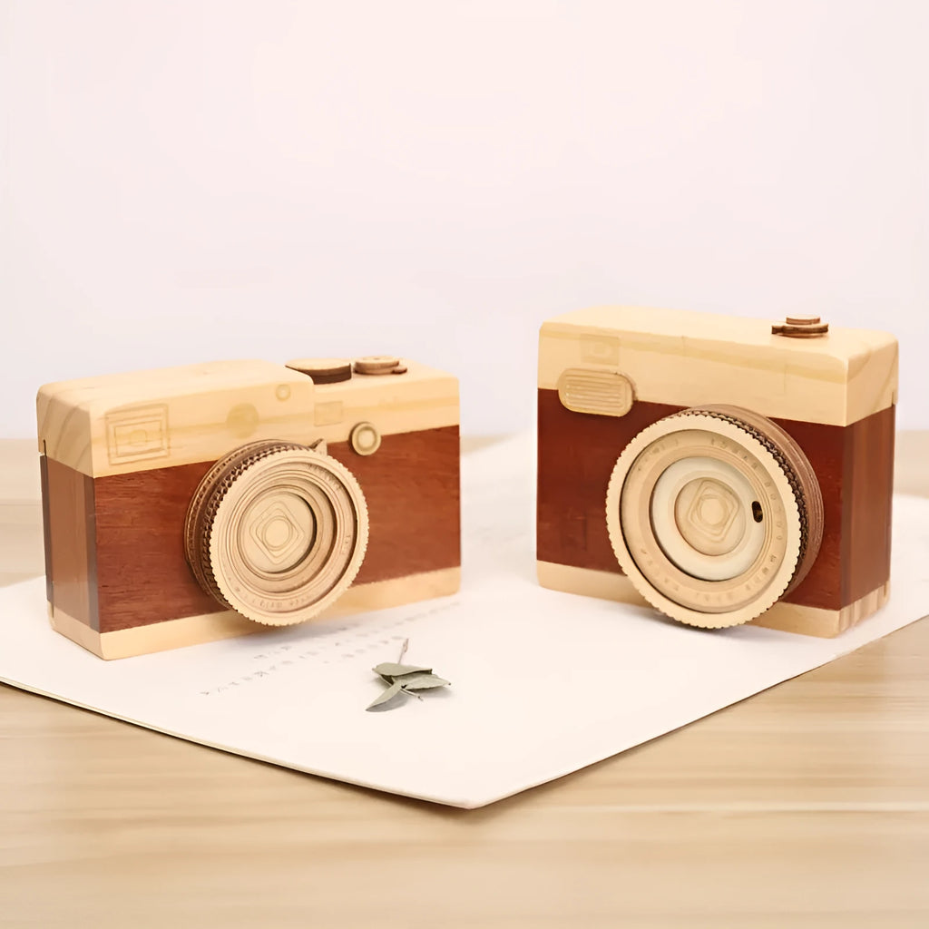 Small wooden music box with rotating camera decoration on pine wood base.