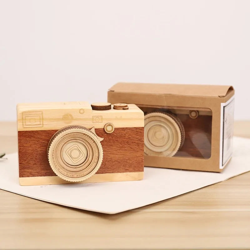Small wooden music box with rotating camera decoration on pine wood base.