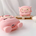 Pink silicone AirPods case with a cartoon pig design and a silver metal keyring hook attached.