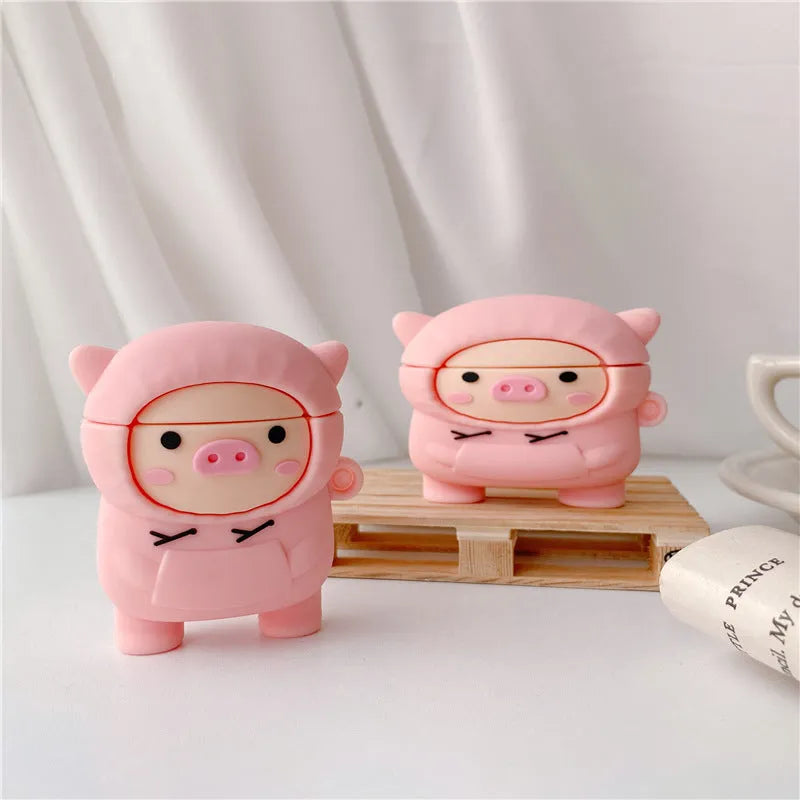 Pink silicone AirPods case with a cartoon pig design and a silver metal keyring hook attached.