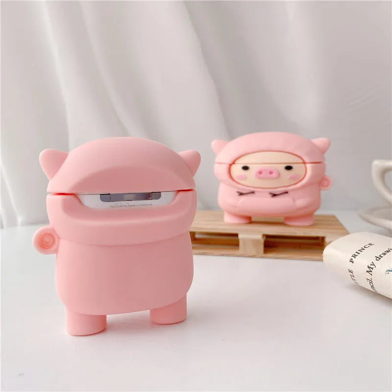 Pink silicone AirPods case with a cartoon pig design and a silver metal keyring hook attached.