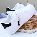 White ladies mesh casual trainers with pink detail and a flat rubber sole.