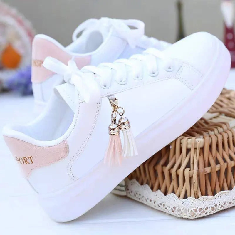 White ladies mesh casual trainers with pink detail and a flat rubber sole.