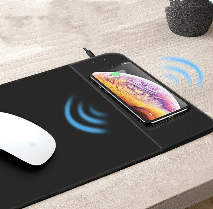 Cartoon pattern wireless charging mouse pad with RGB lighting showing smartphone charging on surface