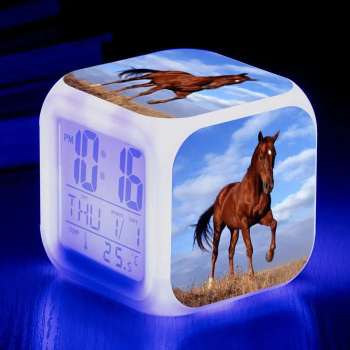 Small square plastic LED alarm clock showing time and temperature on its display.