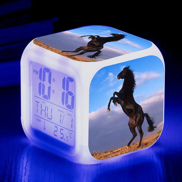 Small square plastic LED alarm clock showing time and temperature on its display.