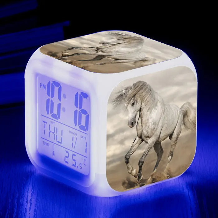 Small square plastic LED alarm clock showing time and temperature on its display.