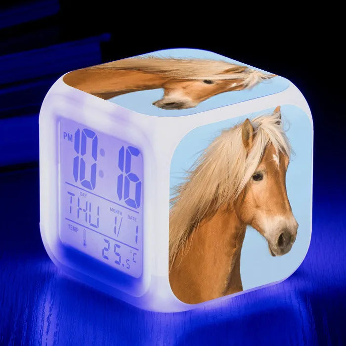 Small square plastic LED alarm clock showing time and temperature on its display.