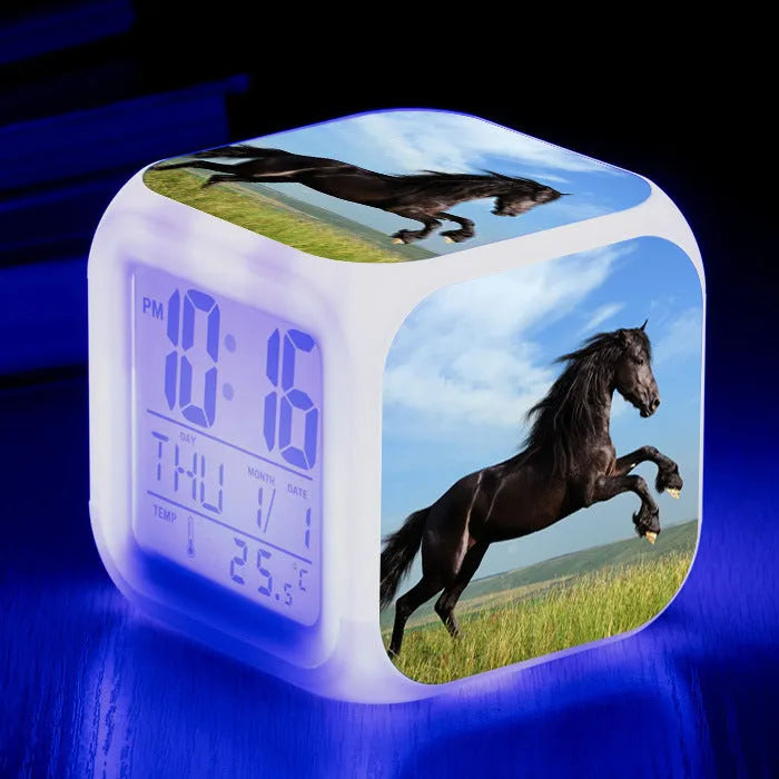 Small square plastic LED alarm clock showing time and temperature on its display.